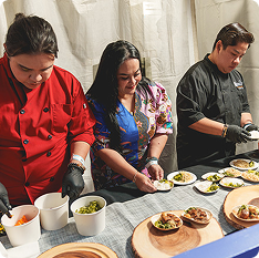 Three Food Bowl vendors preparing and serving dishes